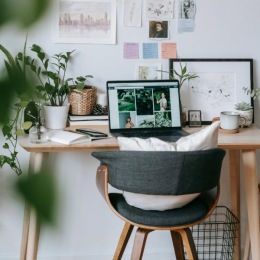 a desk nook with a laptop and artwork