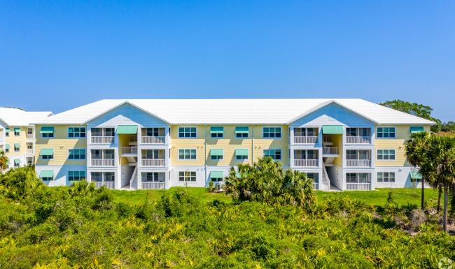 a building with a lot of windows and a green lawn